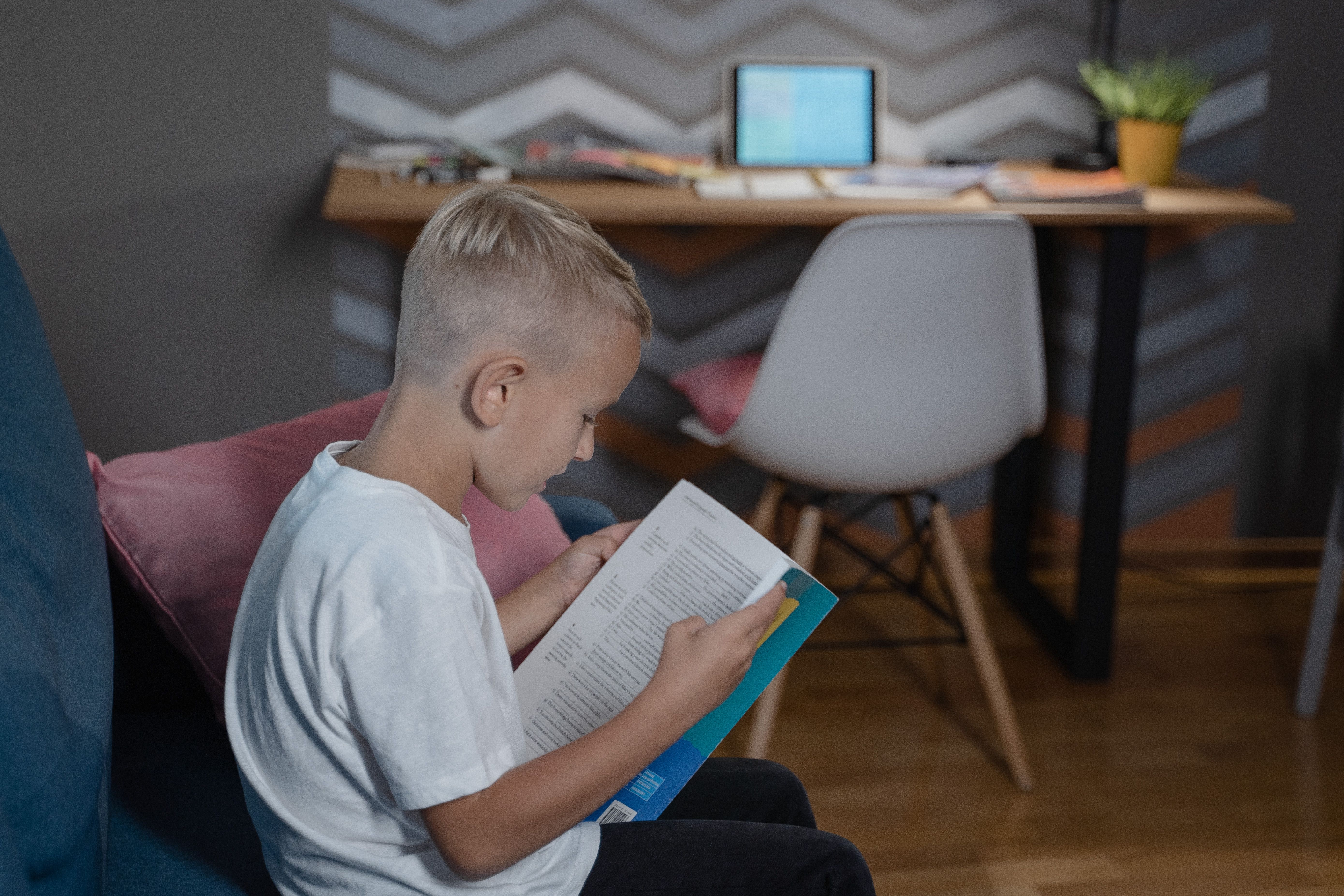 A child reading a book independently at home
